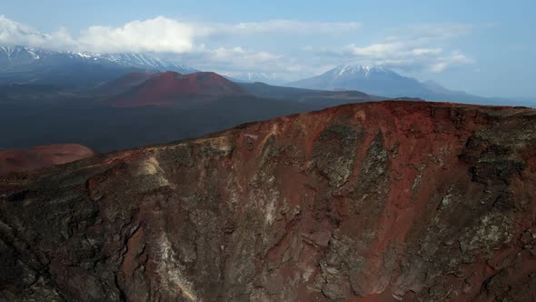 red mountain with a view of snow volcanoes