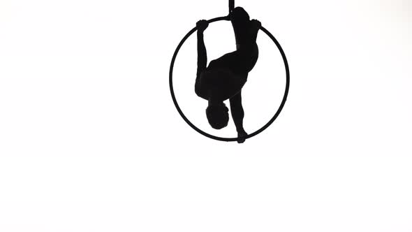 The Black Silhouette of an Aerial Gymnast Performing Acrobatic Tricks and Spinning in the Air on the alt