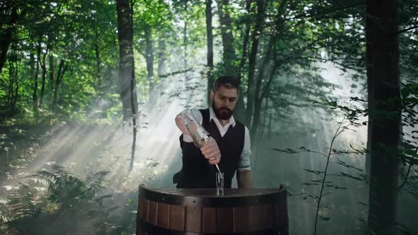 Bartender in Nature in the Forest Prepares a Drink  Shot alt