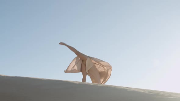 Dancing Young Blond Woman In Gold Dress On Sand alt