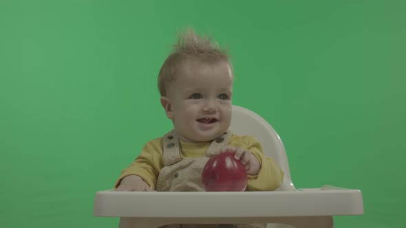 Happy Baby Having Fun and Playing with Apple. alt