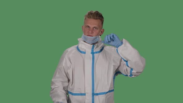 Portrait of a Man in a Protective Suit and Medical Mask Shows Walking Without a Mask Is Bad, Puts on alt