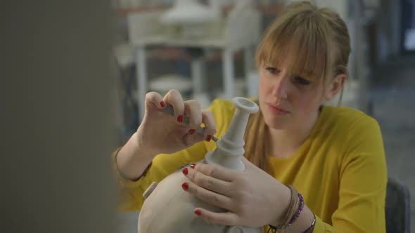 Female artist carving crafts product in workshop