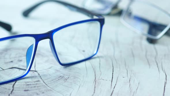 Blue Color Eyeglass on a Wooden Table alt