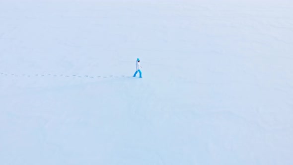 A Girl Walks Through A Snow Covered Field