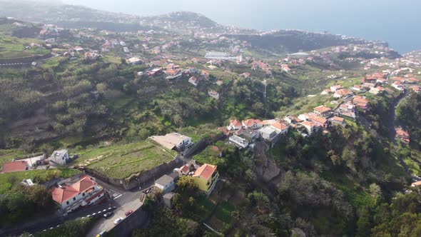 Sea views looking over houses and fields in Ponta Do Sol in Madeira. Shot on DJI. alt