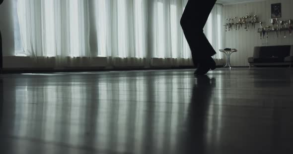 Low Silhouette View of Legs of Dancing Couple Stepping During a Rehearsal alt