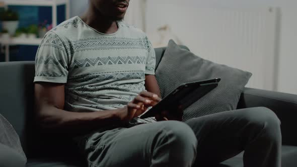 Close Up of Adult Looking at Digital Tablet After Remote Work alt