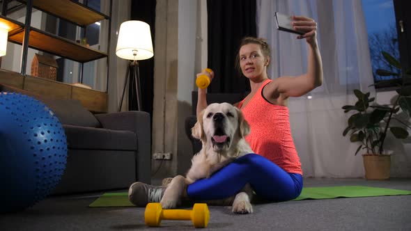 Smiling Fit Female Posing for Selfie Shot with Dog alt