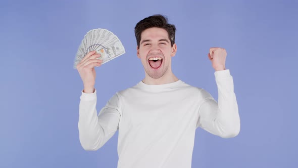 Happy Excited Man with Cash Money  USD Currency Dollars Banknotes on Violet Wall alt