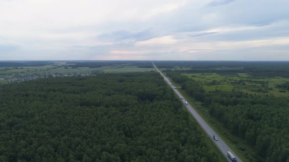 Drone aerial shot of a trucks and cars on the summer forest road near hills, Evening 08 alt