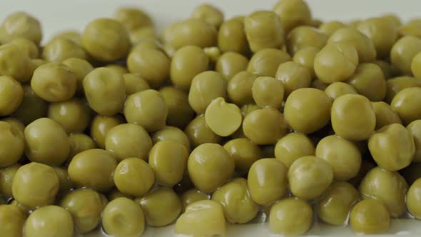 White bowl with canned green peas. Fermented food 