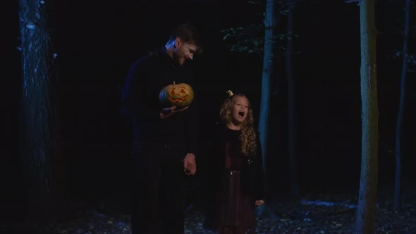 Portrait of Mysterious Vampire and Little Girl Holding Hands Standing in Dark Forest with alt