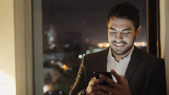 Handsome Young Businessman Smiling After Sending a Voice Message using Smartphone App 5g