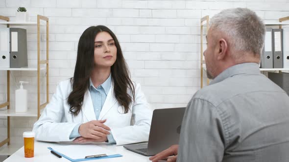 Female Therapist Consulting Senior Male Patient Nodding Head In Office alt
