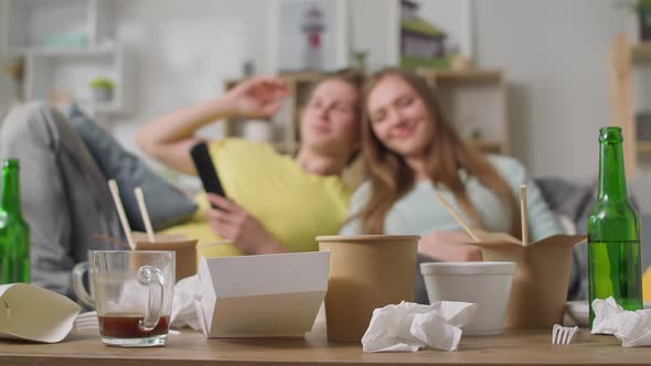 The Guy and the Girl are Lying on the Couch After Gluttony in the Living Room alt