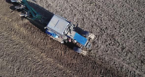 Tractor with a Plow Processes the Soil in Season alt
