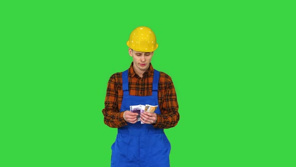 A Workman Counting Cash in Exaggerated Way and Dancing After That on a Green Screen, Chroma Key alt