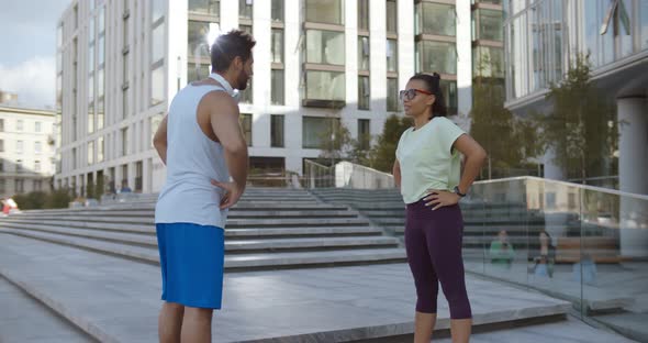 Young Couple in Sport Clothing Doing Stretching Exercises Together Outdoor alt