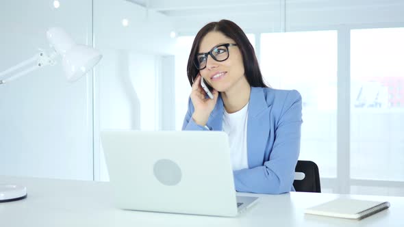 Young Businesswoman Talking on Phone, Attending Call at Work alt