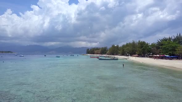 Swimmer snorkel motorboat.Dramatic aerial view flight fly backwards drone footage of Gili Trawangan alt