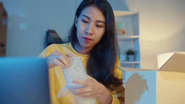 Young Asia businesswoman packing glass use bubble wrap for packing support damage fragile product.
