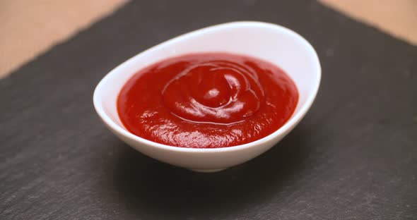 Small serving dish filled with ketchup for dipping. alt