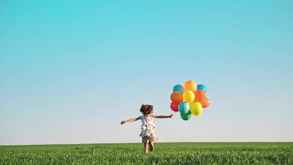 Happy Child Playing with Bright Multicolor Balloons