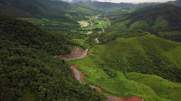 Logistic concept aerial view of countryside road - motorway passing through the serene lush greenery alt