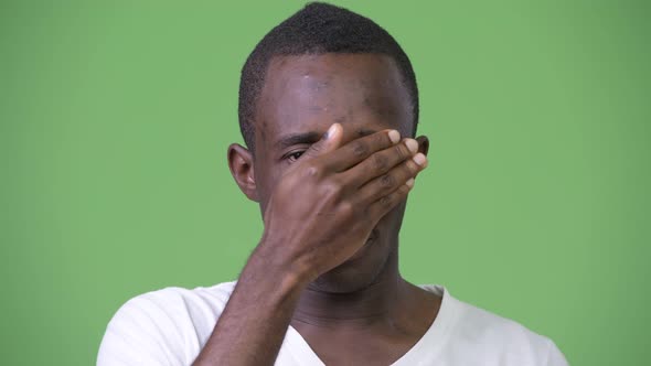 Young African Man Covering Eyes Not Wanting To See Something alt