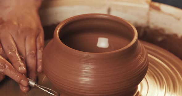 Potter in the Potter's Wheel Makes Ceramic Product Using His Hands and Pottery Tools. Close Up alt
