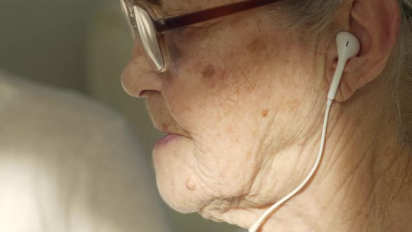 Senior Woman Learning how to Use Earphones with Help of Daughter