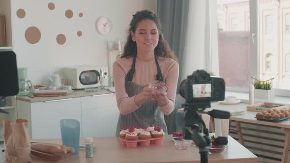 Female Vlogger Decorating Muffins with Berries alt