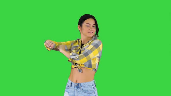 Girl in Square Shirt and Jeans Shorts, Sneakers, Dancing on a Green Screen, Chroma Key. alt