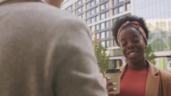  Businesswoman Drinking Coffee and Chatting with Colleague Outside alt