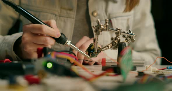 Lady Checks Resistance and Solders Electronic Circuit and Wires in Loft Workshop