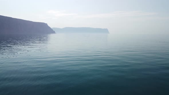Aerial View From Above on Calm Azure Sea and Volcanic Rocky Shores alt