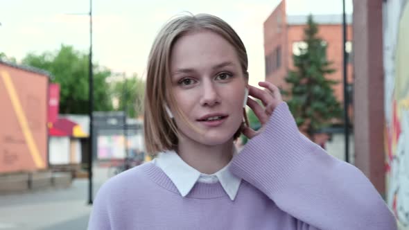 Young Woman with Short Fair Hair and Wireless Headphones alt