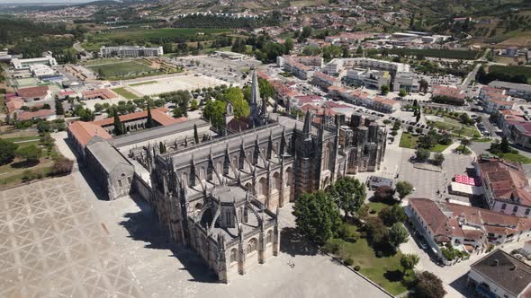 Cityscape of Batalha and majestic Unesco monastery building, aerial orbit view alt