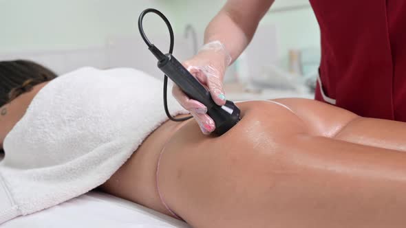 Aesthetician Giving Radio Frequency Treatment to a Woman in the Buttock That Stimulates Healthy Cell alt