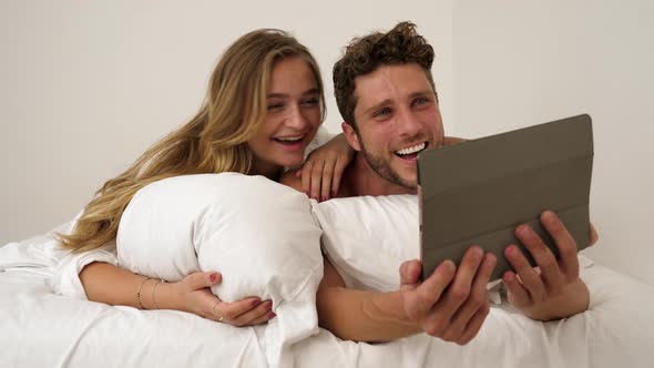 Couple with Tablet in Bed alt
