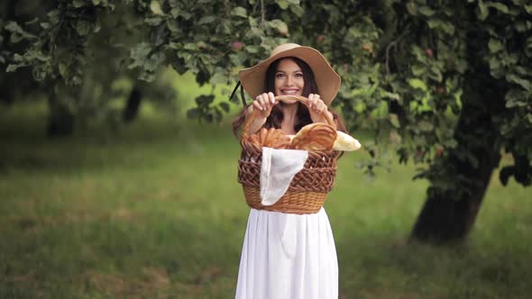 Happy Young Woman in a Straw Hat Walking Ahead