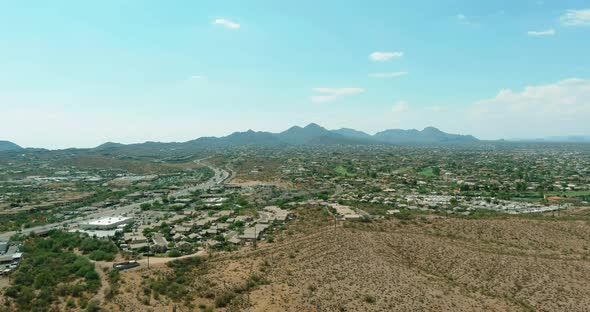 Flight with a Drone Over a with Low Houses in Small Fountain Hills Town Near Mountain Desert a Sunny alt