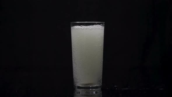 Effervescent Tablet Falling in Glass of Water