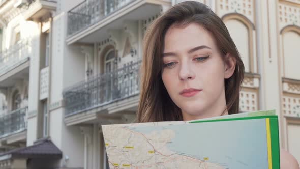 Happy Beauitful Woman Smiling To the Camera While Using a Map