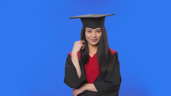 Portrait of Female Student in Cap and Gown Graduation Flirtatiously Smiles Shows Call Me alt