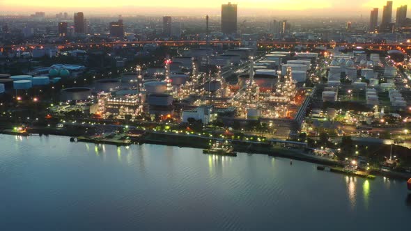 4k aerial view drone of refinery oil petroleum production factory with river reflecting surface sunr alt