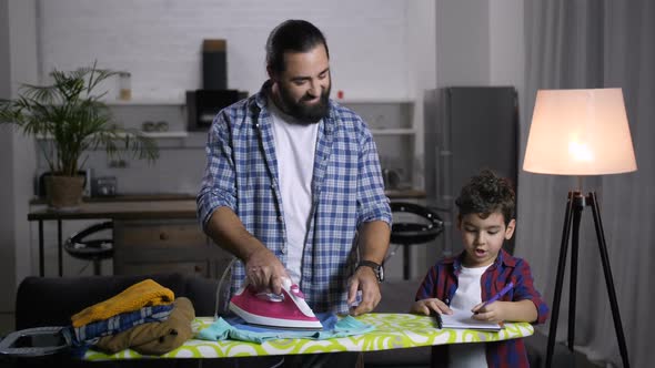 Stay-at-home Dad Assisting Son with Schoolwork alt