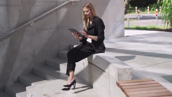 Female Manager Using Tablet on Steps alt
