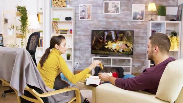 Back View of Young Couple Eating Fried Chicken alt